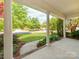 Covered front porch featuring white columns and a view of the beautifully landscaped front yard at 533 Montgrove Nw Pl, Concord, NC 28027