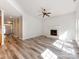 Sunlit living room with a fireplace, gray wood floors, and views into the kitchen and foyer at 533 Montgrove Nw Pl, Concord, NC 28027