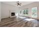 Bright living room with gray floors, a cozy fireplace, and large windows offering plenty of natural light at 533 Montgrove Nw Pl, Concord, NC 28027