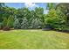 Lush green backyard with mature trees and trampoline, offering a serene outdoor space at 581 Medora Ln, Fort Mill, SC 29708
