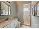 Well-lit bathroom with a stone countertop, sink, toilet, mirror, and glass door shower at 581 Medora Ln, Fort Mill, SC 29708