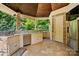 Outdoor kitchen in cabana featuring stainless steel appliances, sink, and stone detailing at 581 Medora Ln, Fort Mill, SC 29708