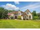 Stunning home featuring stone accents, a well-manicured lawn, and professionally landscaped greenery at 581 Medora Ln, Fort Mill, SC 29708