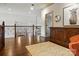 Hallway with hardwood floors and railing overlooking the living room area with fireplace at 581 Medora Ln, Fort Mill, SC 29708