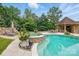 Gorgeous pool with hot tub and cabana featuring stone accents surrounded by lush landscaping at 581 Medora Ln, Fort Mill, SC 29708