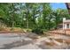 Well-maintained backyard with mature trees, brick accents, and landscaping, creating a serene outdoor space at 603 Sunnybrook Dr, Monroe, NC 28110