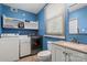 Functional laundry room with modern washer and dryer, vanity, and storage shelves at 603 Sunnybrook Dr, Monroe, NC 28110