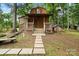Charming outbuilding with a cozy front porch, situated amidst mature trees offering a secluded retreat at 603 Sunnybrook Dr, Monroe, NC 28110