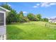 Spacious backyard featuring lush green grass, mature trees, and a gentle slope, creating a serene outdoor retreat at 6227 Castlecove Rd, Charlotte, NC 28278