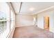 A large, bright bedroom featuring a tray ceiling and multiple windows at 6227 Castlecove Rd, Charlotte, NC 28278