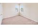 Minimalist bedroom with carpet flooring and natural light from two windows at 6227 Castlecove Rd, Charlotte, NC 28278