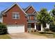 Charming two-story brick home with a well-manicured lawn and attached two-car garage at 6227 Castlecove Rd, Charlotte, NC 28278