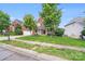 A lovely brick home with a two-car garage surrounded by a green lawn and mature shade trees at 6227 Castlecove Rd, Charlotte, NC 28278