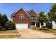 Charming two-story brick home with a well-manicured lawn and attached two-car garage at 6227 Castlecove Rd, Charlotte, NC 28278