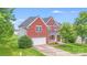 Charming two-story brick home with a well-manicured lawn and an attached two-car garage at 6227 Castlecove Rd, Charlotte, NC 28278