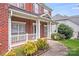 Charming porch with white railings and columns on a brick home with tidy landscaping at 6227 Castlecove Rd, Charlotte, NC 28278