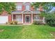 Inviting front porch of a brick home, featuring white columns and a well-kept lawn at 6227 Castlecove Rd, Charlotte, NC 28278