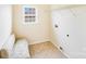 Well-lit laundry room featuring a bench, window, tile floor and hookups at 6227 Castlecove Rd, Charlotte, NC 28278