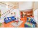 Bright and airy living room featuring a staircase and hardwood floors leading to a modern kitchen at 6227 Castlecove Rd, Charlotte, NC 28278