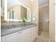 Modern bathroom featuring dual vanities, illuminated mirror, and glass-enclosed shower at 6312 Mission Pl, Charlotte, NC 28210