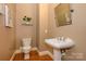 Charming half bathroom with pedestal sink and hardwood floors at 6312 Mission Pl, Charlotte, NC 28210