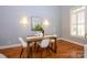 Cozy dining area featuring hardwood floors, a modern light fixture, and a bright window at 6312 Mission Pl, Charlotte, NC 28210