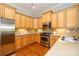 Well-lit kitchen features stainless steel appliances, wooden cabinetry, and sleek countertops at 6312 Mission Pl, Charlotte, NC 28210