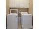 Bright laundry room featuring a white, modern washer and dryer with upper white cabinets at 6312 Mission Pl, Charlotte, NC 28210