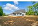 The backyard features a blue home with large windows, a well-manicured lawn, and plenty of space for outdoor activities at 910 Westminster Dr, Statesville, NC 28677