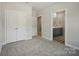 Spacious bedroom featuring a view of the ensuite bathroom and closet, with neutral walls and gray carpet at 910 Westminster Dr, Statesville, NC 28677