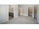 Spacious bedroom with carpeted floor, featuring a view of the ensuite bathroom, closet, and neutral colored walls at 910 Westminster Dr, Statesville, NC 28677