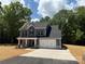 Two-story home with a two car garage, welcoming front porch, and classic dark gray siding at 910 Westminster Dr, Statesville, NC 28677