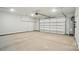 Spacious two car garage with concrete floor, white walls and ceiling, and carriage style garage door at 910 Westminster Dr, Statesville, NC 28677