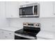 Close-up of the stainless steel microwave and oven, with white subway tile backsplash at 910 Westminster Dr, Statesville, NC 28677