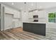 Modern kitchen with island, white cabinets, and stainless steel appliances at 910 Westminster Dr, Statesville, NC 28677