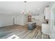 Open-concept living room features a chandelier, kitchen island, and luxury vinyl plank flooring at 910 Westminster Dr, Statesville, NC 28677