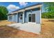 Backyard featuring a concrete patio, blue siding, white trim, large windows, and a sliding glass door at 910 Westminster Dr, Statesville, NC 28677