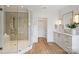 Modern bathroom with a glass-enclosed shower, double vanity sinks, and light wood flooring at 922 Everett Pl, Charlotte, NC 28205