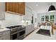 Spacious kitchen featuring stainless steel appliances, a wooden range hood, and an open layout to the dining area at 922 Everett Pl, Charlotte, NC 28205