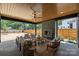 Covered outdoor living space with a stone fireplace, comfortable seating, and views of the backyard at 922 Everett Pl, Charlotte, NC 28205