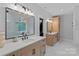 Bright bathroom featuring double vanities, quartz countertops, and decorative mirrors at 9564 Regent Dr, Davidson, NC 28036
