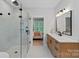 Luxurious bathroom with frameless glass shower, rainfall shower head, and marble tile at 9564 Regent Dr, Davidson, NC 28036