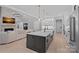 Open kitchen with central island, stone fireplace in the living room, and hardwood floors at 9564 Regent Dr, Davidson, NC 28036