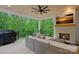 Outdoor patio featuring a fireplace, television, and comfortable seating with wooded backyard at 9564 Regent Dr, Davidson, NC 28036