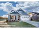 Charming single-Gathering home with blue siding, stone accents, a two-car garage, and manicured lawn at 106 S Inneswood Ln # 31, Mooresville, NC 28115