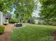 Expansive backyard with a paver patio, mature trees, and a detached garage at 1069 Sedgefield Rd, Charlotte, NC 28209