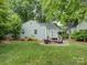 Lush backyard with a paver patio and seating, surrounded by mature trees and landscaping at 1069 Sedgefield Rd, Charlotte, NC 28209