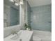 Updated bathroom with modern blue tiling in the shower and vanity with integrated sink at 1069 Sedgefield Rd, Charlotte, NC 28209