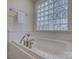 White soaking tub featuring sleek chrome fixtures and decorative tile at 1069 Sedgefield Rd, Charlotte, NC 28209