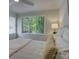 Bright bedroom with hardwood floors and a large window overlooking mature landscaping at 1069 Sedgefield Rd, Charlotte, NC 28209